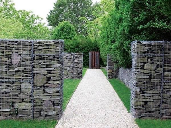 Four welded garden gabion walls are filled with rocks standing along roadside.