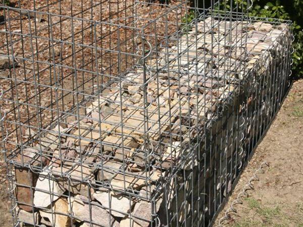 2-layer gabion wall is being installed with spiral wires outdoors.