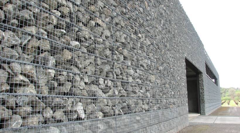 La pared de la casa está hecha de gaviones soldados llenos de piedras.
