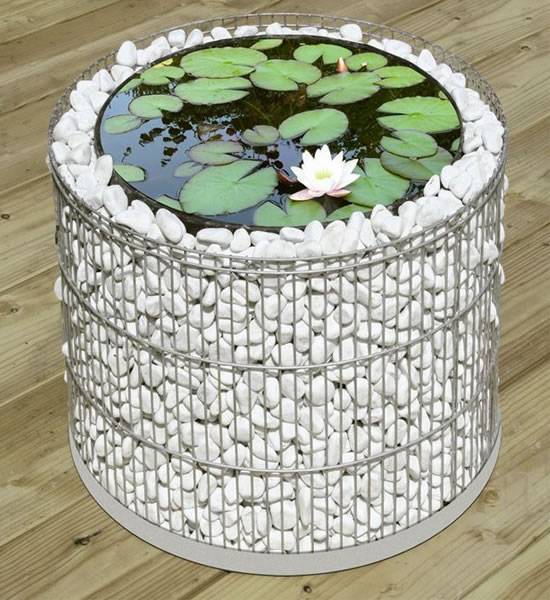 Column shape gabion planters filled with white stones are used as water scene.