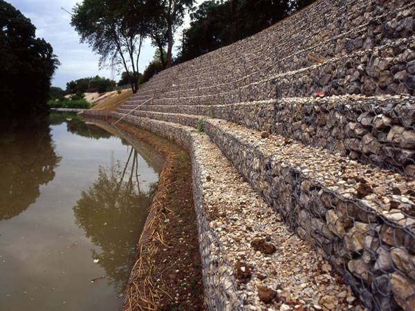 Several layers of gabions are installed on the river bank.