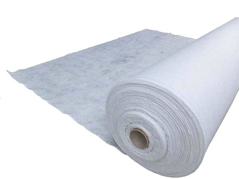 В канал помещается несколько кусков геотекстильной ткани белого цвета.