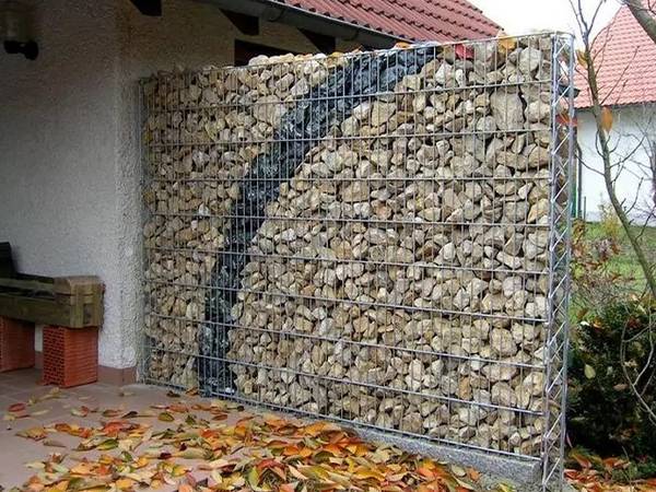 A gabion wall is installed in the yard.
