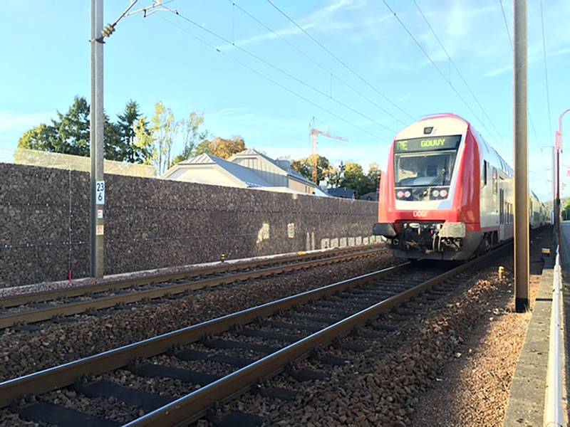 A line of welded gabions are installed side of railway.