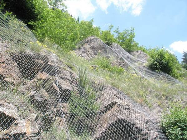 Rockfall barriers covers a high mountain.