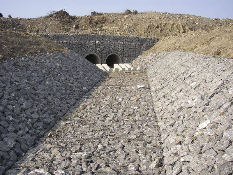 A channel is paved with welded gabions filled with stones.